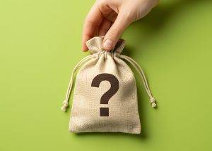 A hand holds a small drawstring bag with a large question mark on the front against a green background, symbolizing hidden business expenses and uncertainty around unmanaged printing costs.