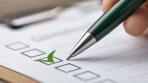 Green pen checking items on printed list for professional review and organization. Assessment concept.