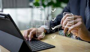 Businessman verifies and manages digital paperwork on a laptop using an automated system, expressing document approval, quality control, and efficient workflow management before final task delivery.