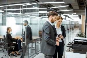 Business man and woman conducting a print assessment by the copier