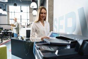 Employee using modern office printer in office